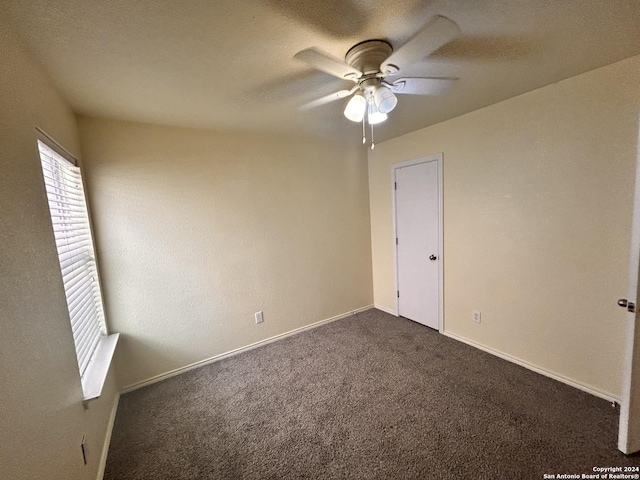 6050 Lakefront, San Antonio, TX 78222 - unfurnished room featuring ceiling fan, dark colored carpet, and baseboards