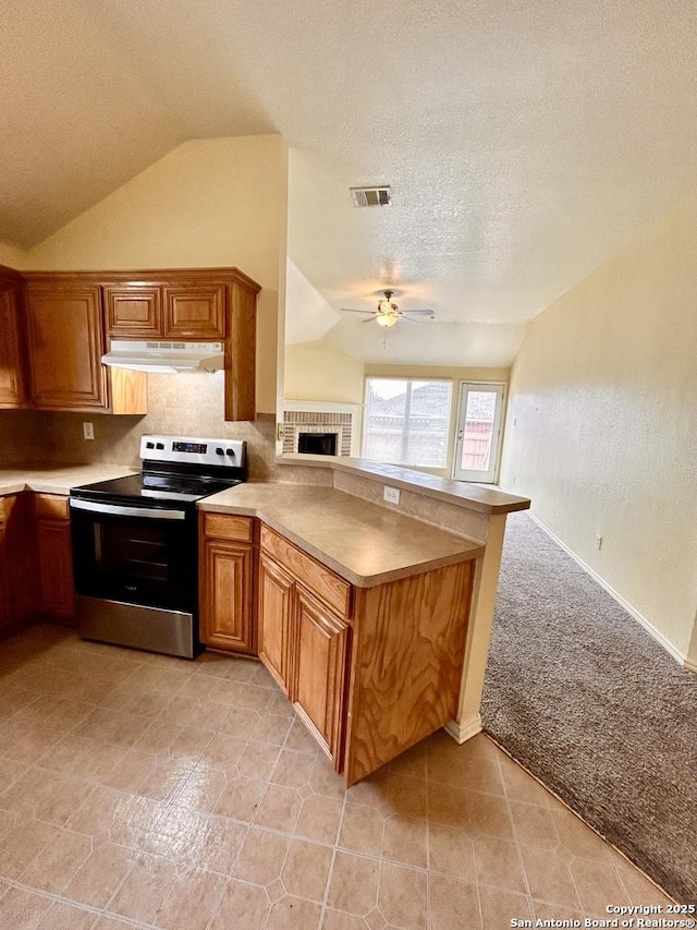 6050 Lakefront, San Antonio, TX 78222 - kitchen featuring stainless steel range with electric cooktop, vaulted ceiling, under cabinet range hood, a ceiling fan, and a peninsula