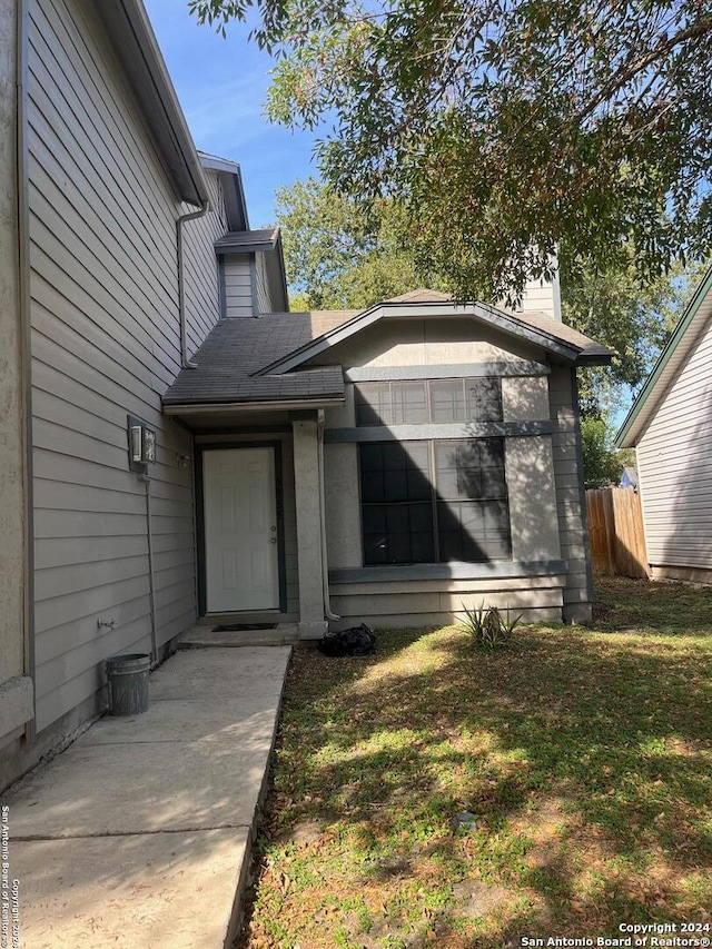 doorway to property featuring a lawn