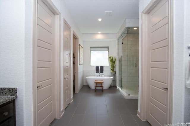 bathroom with vanity, tile patterned flooring, and plus walk in shower