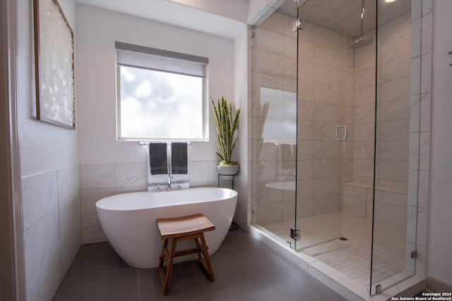 bathroom featuring tile patterned floors, independent shower and bath, and tile walls