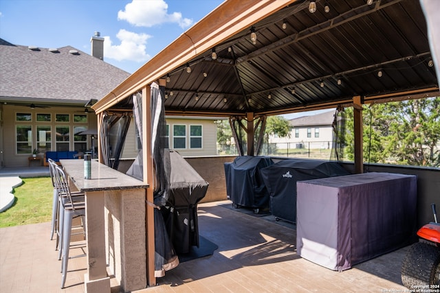 view of patio / terrace featuring a gazebo, grilling area, and exterior bar