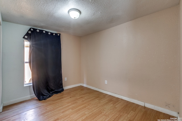 empty room featuring light hardwood / wood-style floors and a textured ceiling