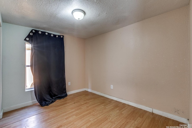 125 Forrest Ave, San Antonio, TX 78204 - spare room featuring wood finished floors, a textured ceiling, and baseboards
