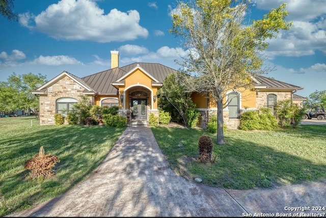 ranch-style house featuring a front yard and french doors