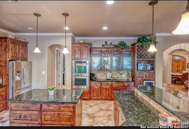 kitchen featuring decorative backsplash, appliances with stainless steel finishes, ornamental molding, pendant lighting, and a kitchen island