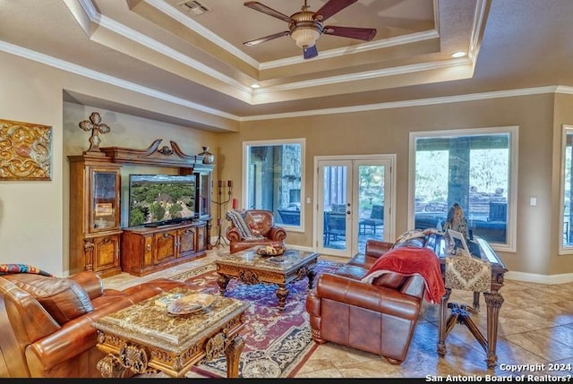 living room featuring french doors, a raised ceiling, ceiling fan, and ornamental molding