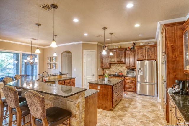 kitchen featuring ornamental molding, stainless steel appliances, a spacious island, sink, and pendant lighting