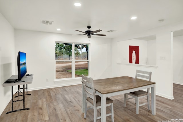 dining space with ceiling fan and light hardwood / wood-style flooring