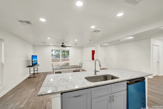 kitchen featuring sink, stainless steel dishwasher, ceiling fan, an island with sink, and light hardwood / wood-style floors