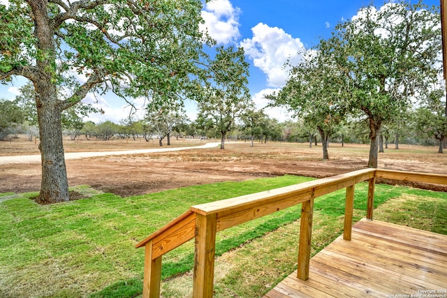 view of yard featuring a rural view and a wooden deck