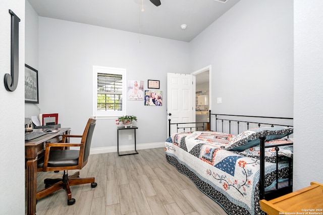 bedroom featuring ceiling fan, a high ceiling, and light wood-type flooring