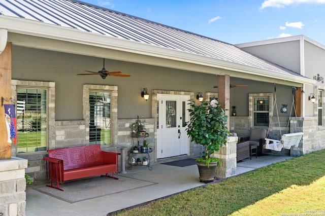 view of exterior entry featuring ceiling fan and a patio area