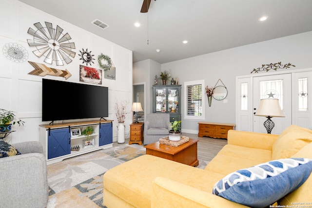 living room with light hardwood / wood-style flooring and ceiling fan