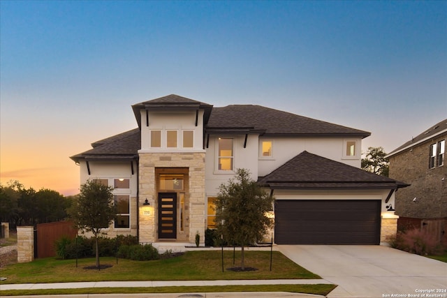 view of front of home with a garage and a yard