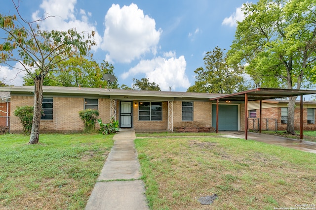 ranch-style house featuring a garage, a front yard, and a carport