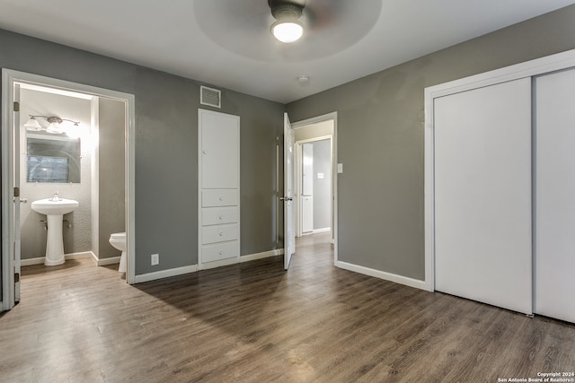 unfurnished bedroom featuring hardwood / wood-style flooring, ceiling fan, sink, and connected bathroom