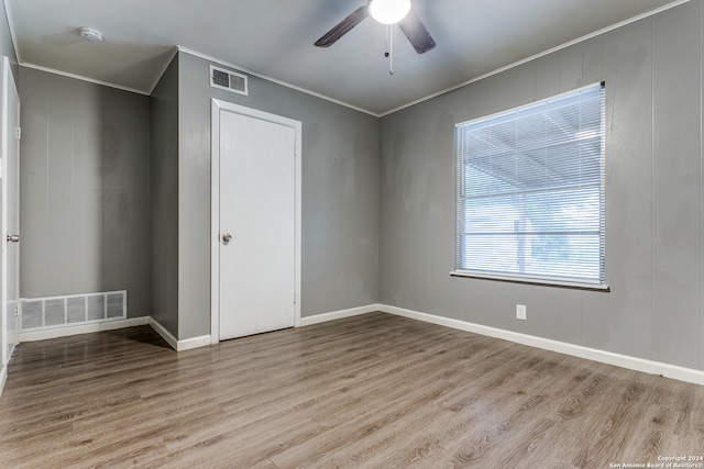 empty room with crown molding, light hardwood / wood-style flooring, and ceiling fan