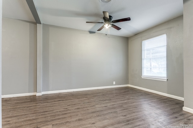 empty room with ceiling fan and dark hardwood / wood-style flooring