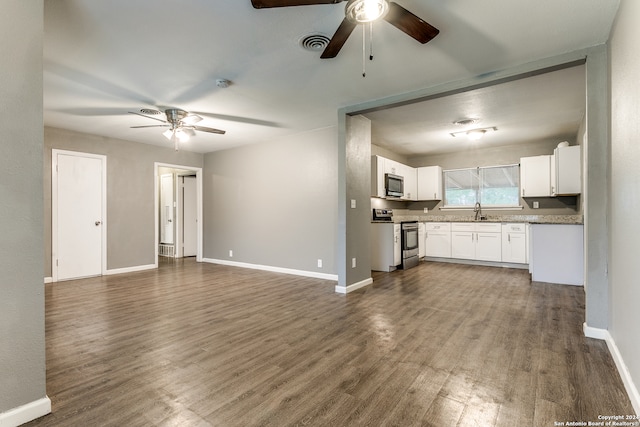 kitchen with stainless steel appliances, ceiling fan, dark wood-type flooring, sink, and white cabinetry