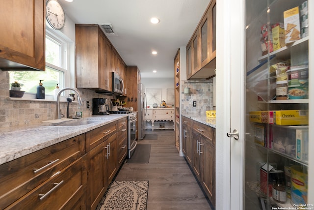 kitchen with dark hardwood / wood-style flooring, decorative backsplash, sink, and light stone countertops