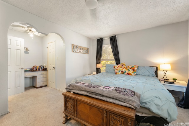 carpeted bedroom with ceiling fan and a textured ceiling