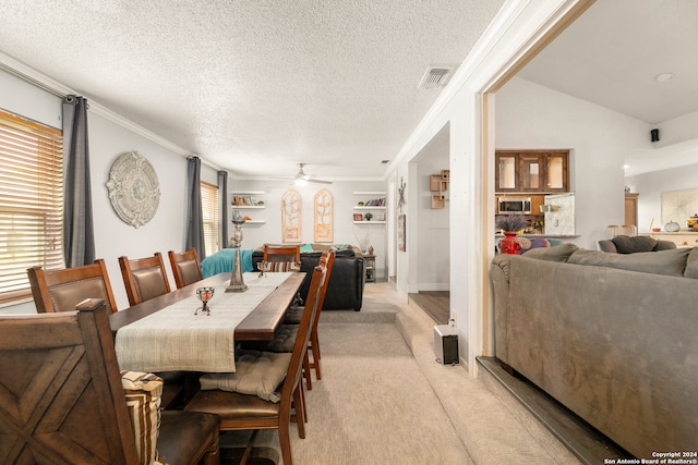 carpeted dining room featuring a textured ceiling, ceiling fan, crown molding, and vaulted ceiling