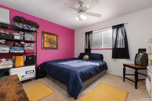 carpeted bedroom with ceiling fan and a textured ceiling