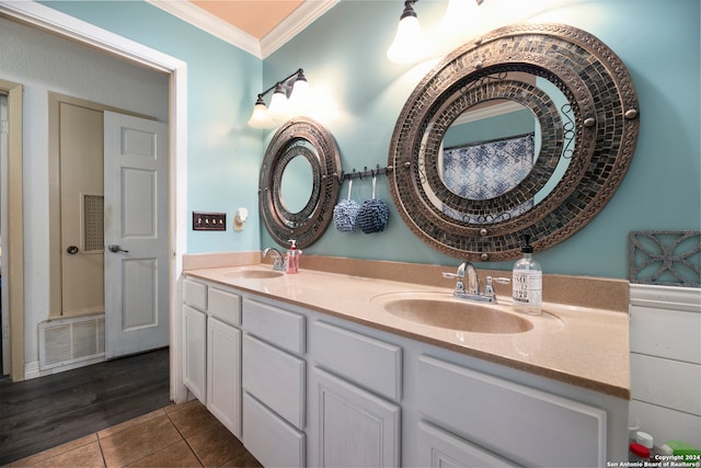 bathroom featuring vanity, wood-type flooring, and ornamental molding