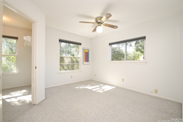 carpeted spare room with ceiling fan and a healthy amount of sunlight