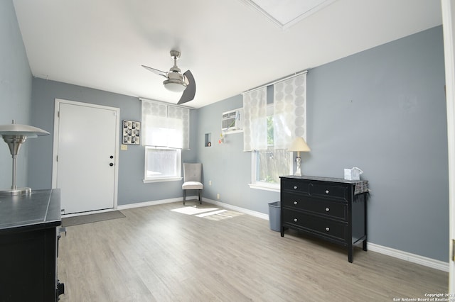 interior space with a wealth of natural light, ceiling fan, a wall mounted air conditioner, and light wood-type flooring