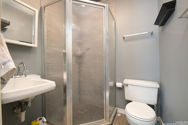 bathroom with sink, an enclosed shower, and toilet