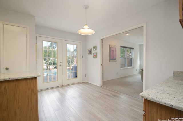 unfurnished dining area with french doors and light hardwood / wood-style floors