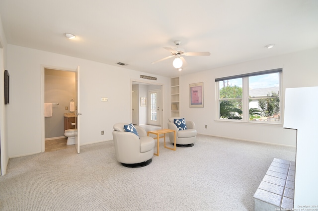 living area with ceiling fan and light colored carpet