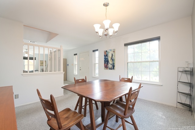 dining area with light colored carpet and an inviting chandelier