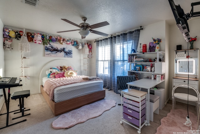 bedroom with ceiling fan, light carpet, and a textured ceiling