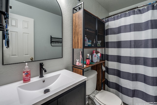 bathroom with a shower with shower curtain, vanity, toilet, and a textured ceiling