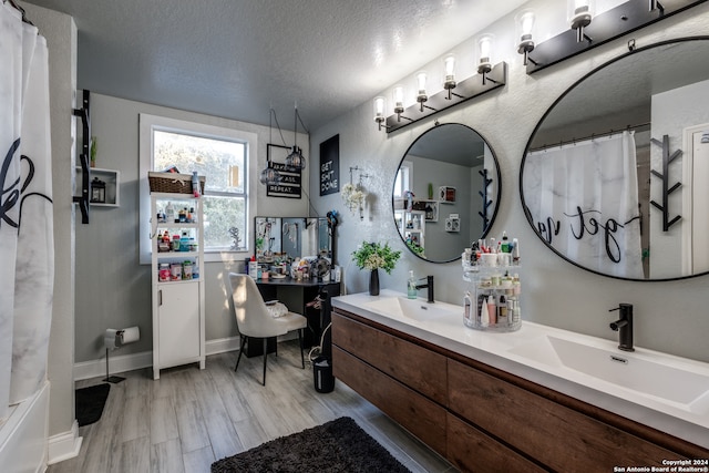 bathroom featuring vanity, a textured ceiling, hardwood / wood-style flooring, and walk in shower