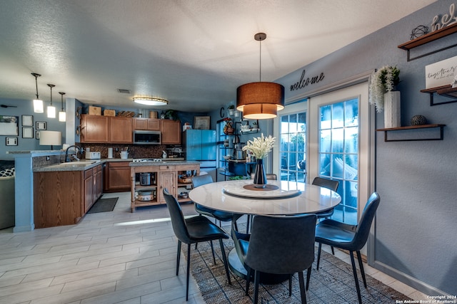 dining area featuring sink and a textured ceiling