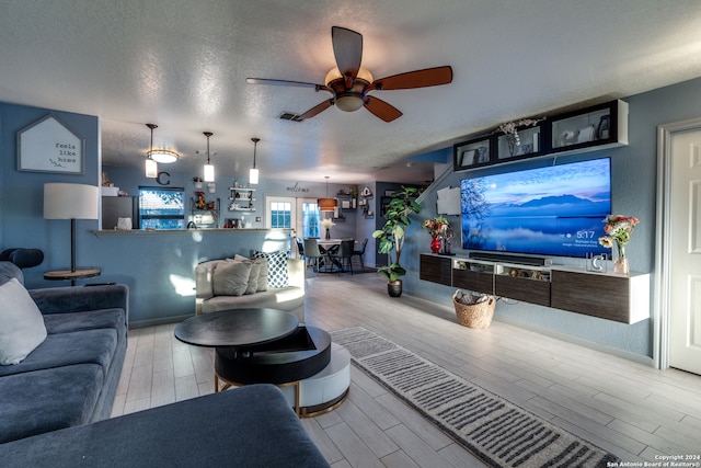 living room with a textured ceiling and ceiling fan