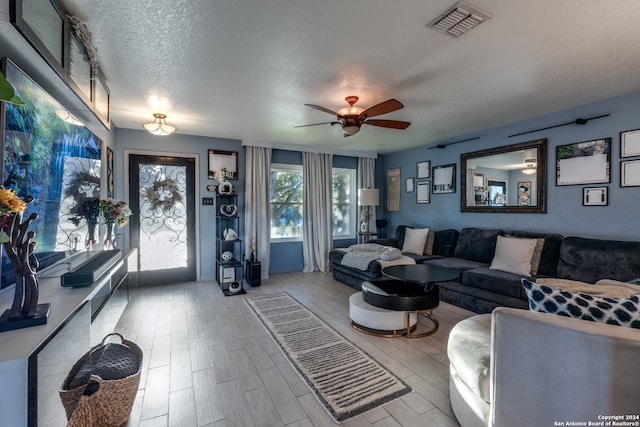 living room with ceiling fan and a textured ceiling