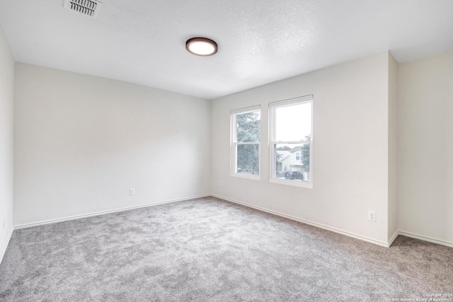 empty room with carpet and a textured ceiling