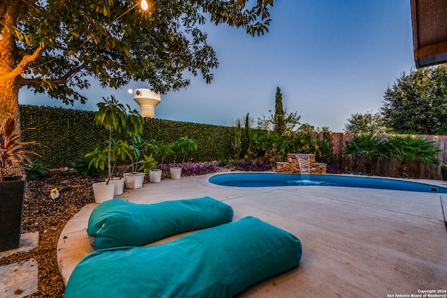 pool at dusk with a patio