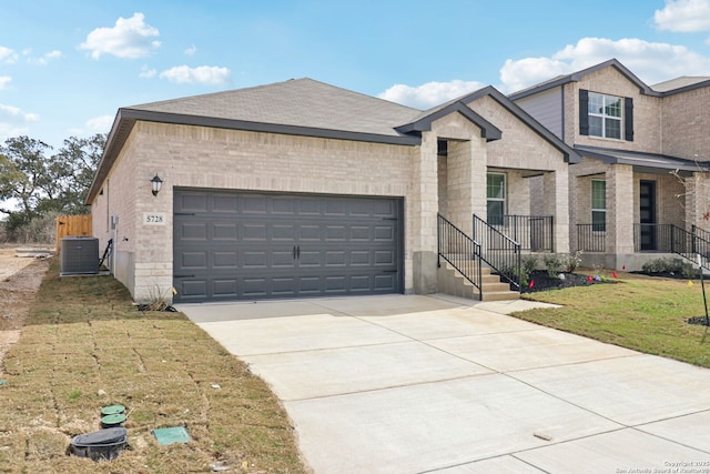5728 Sendero Rnch, San Antonio, TX 78253 - view of front facade with central air condition unit, a garage, brick siding, concrete driveway, and a front lawn