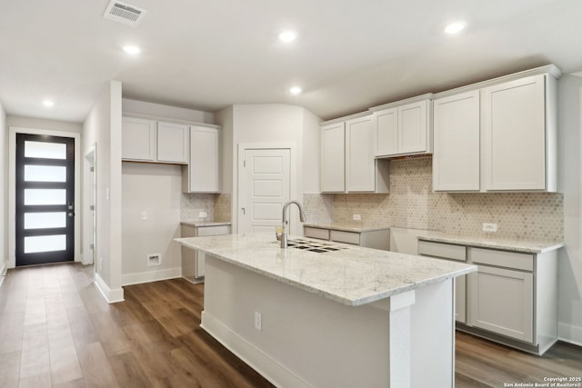 kitchen featuring white cabinetry, sink, and a center island with sink