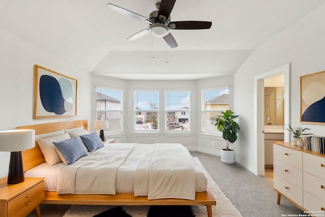 carpeted bedroom featuring lofted ceiling, multiple windows, ceiling fan, and ensuite bathroom