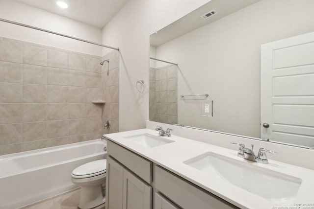 full bathroom with tiled shower / bath, vanity, and toilet