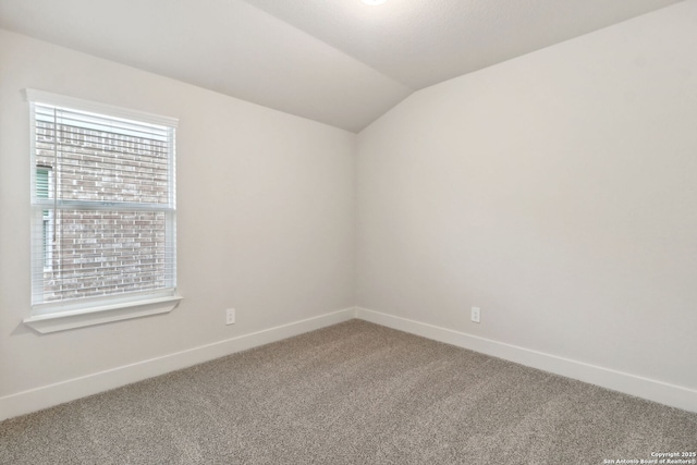 unfurnished room featuring vaulted ceiling and carpet floors