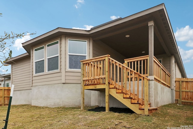 back of house with a wooden deck and a lawn