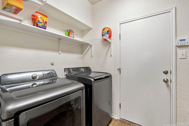 clothes washing area with washer and clothes dryer and light tile patterned floors